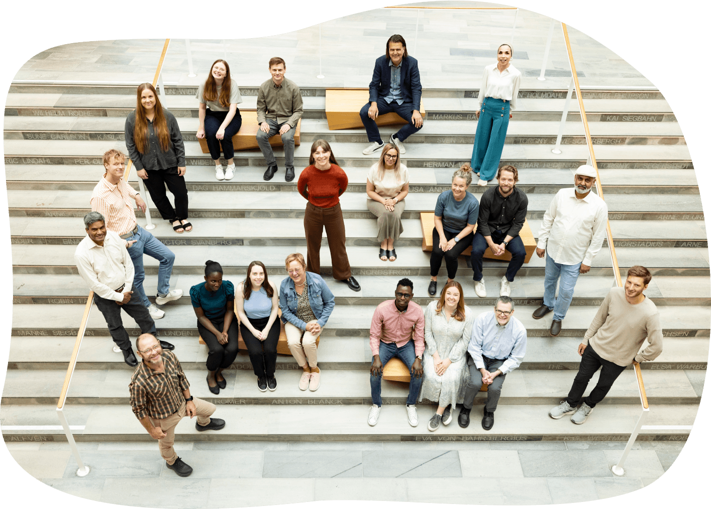 A photo of the people working in the U-CARE Group posed on wide stairs, arranged at various levels